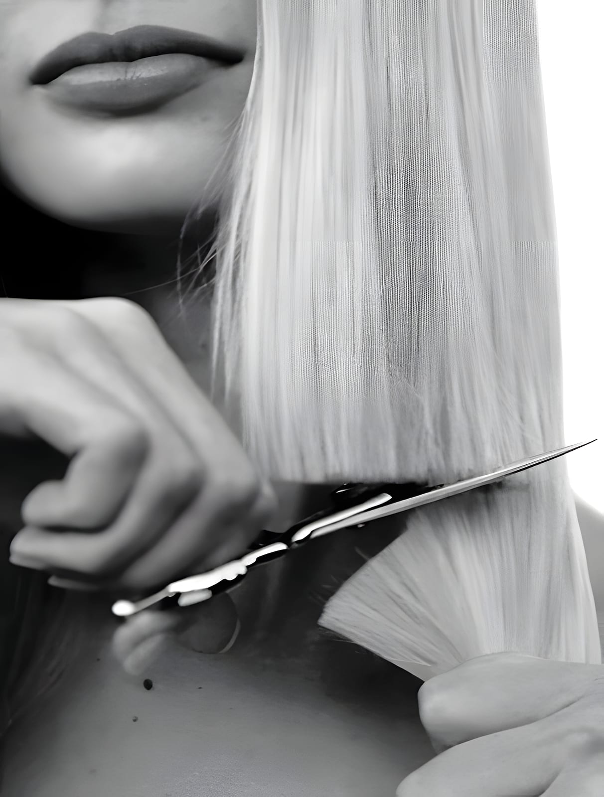 Black and white close-up of scissors cutting blonde hair near a person's lips