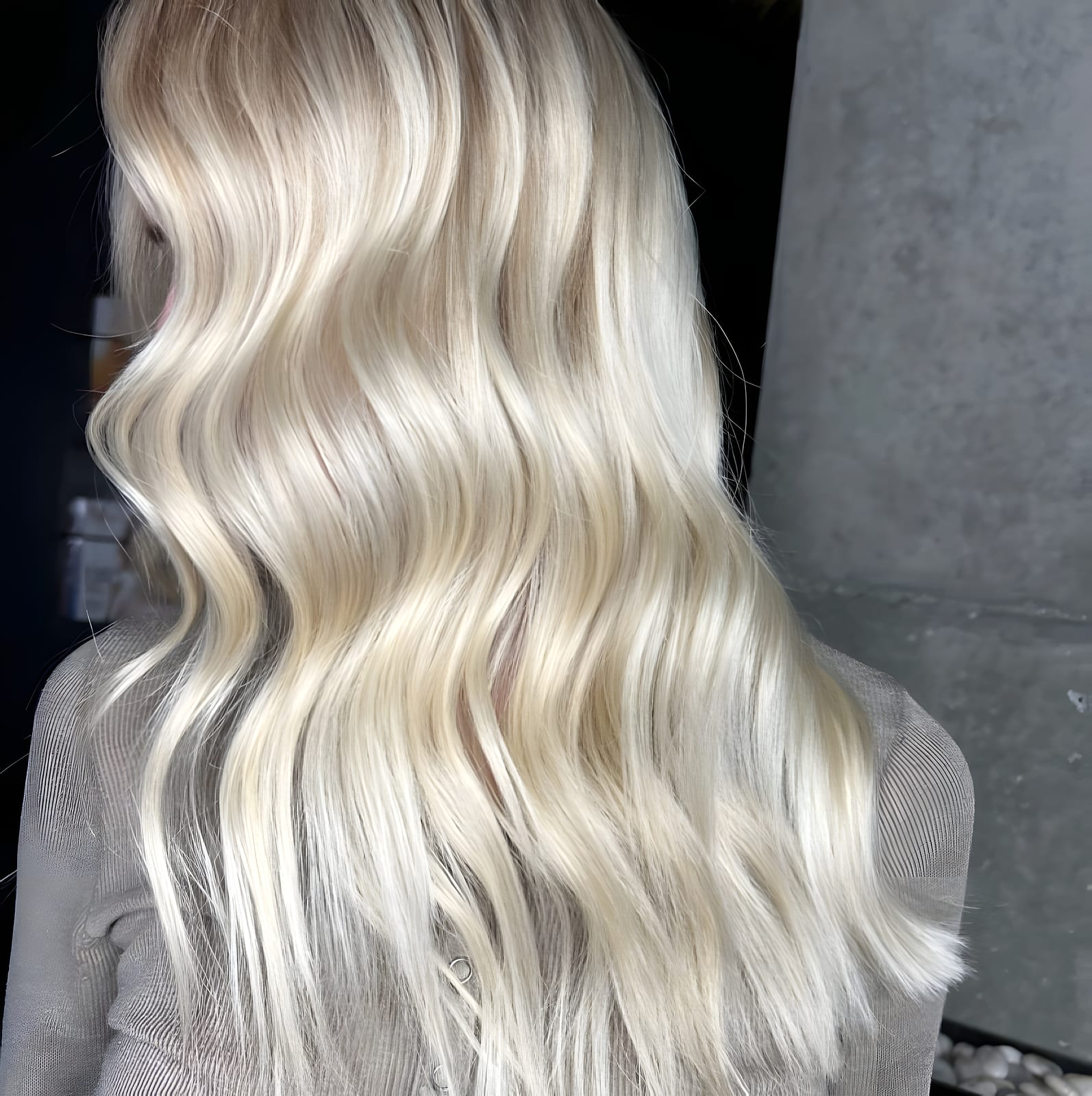 Back view of wavy platinum blonde hair in the salon