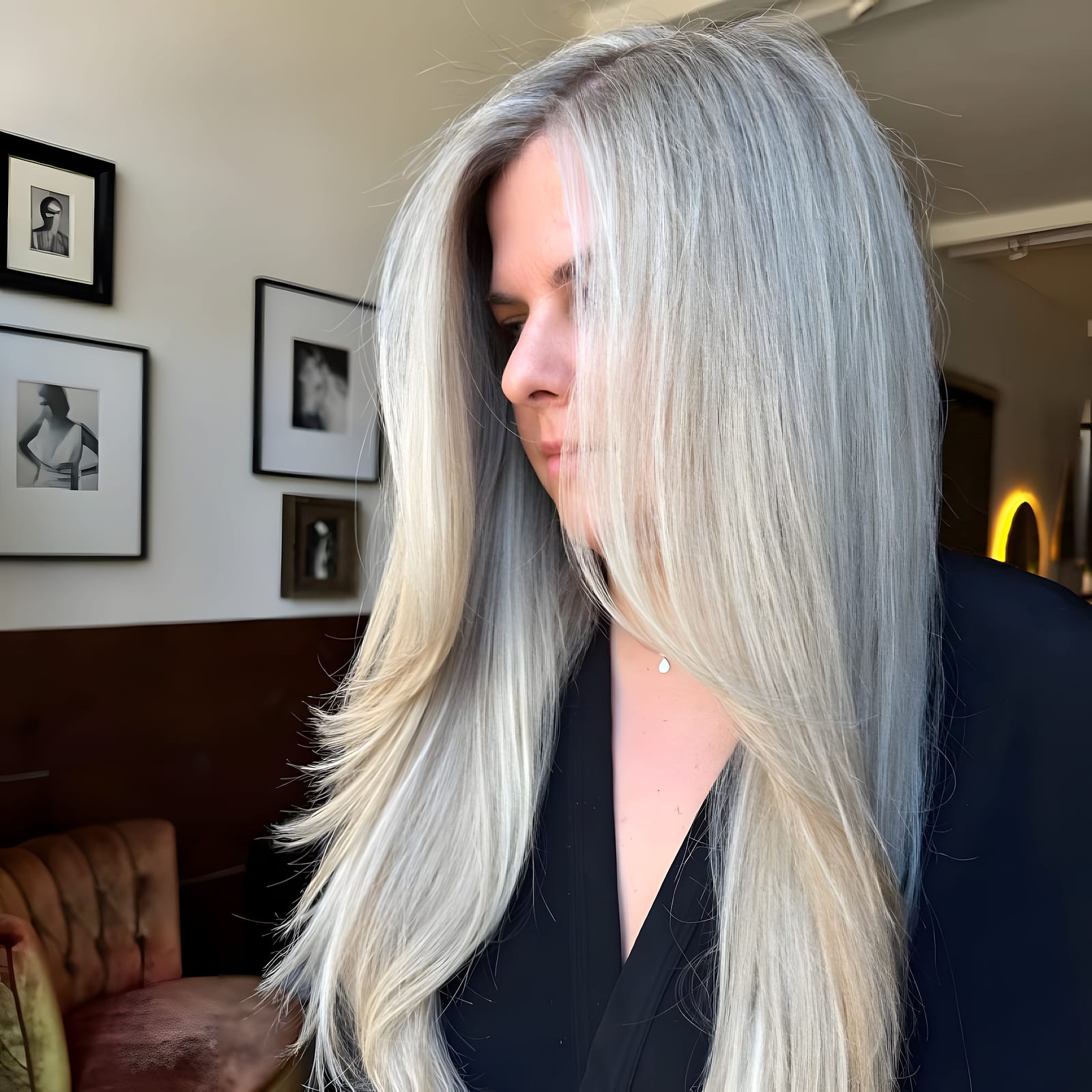 Woman with long silver-blonde hair in profile inside the decorated salon